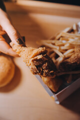 close up focus woman hand hold fried chicken for eat,girl with fast food concept