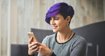 Confident, happy, non.binary person having a video chat with their friend using a smartphone. Shallow depth of field portrait.