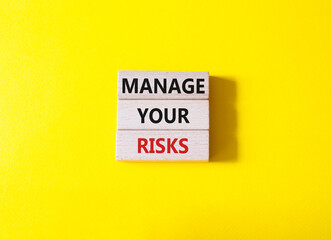 Manage your Risks symbol. Concept words Manage your Risks on wooden blocks. Beautiful yellow background. Business and Manage your Risks concept. Copy space.