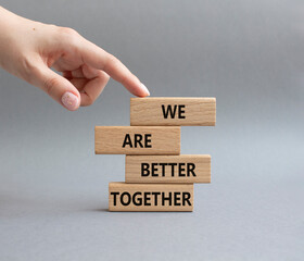 We are better together symbol. Wooden blocks with words We are better together. Beautiful grey background. Businessman hand. We are better together concept. Copy space.