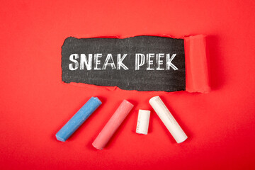 SNEAK PEEK. Text under torn red paper on a blackboard