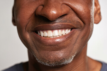 Fototapeta premium portrait of a mature man smiling, smile with perfect teeth, closeup on lips of a man, dental care, dentist advertising