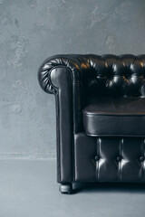 Armrest detail of black leather classic upholstered armchair