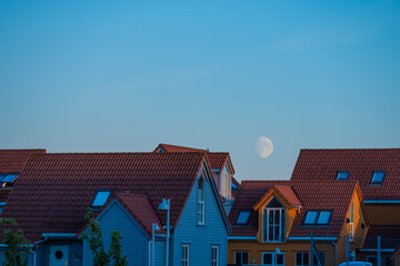The moon rising over a row of summer houses.