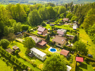 Aerial view of houses and gardens with pool. Living with nature in the village.