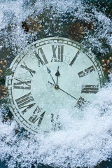 New Years clock and fir branches covered with snow flakes, flat lay