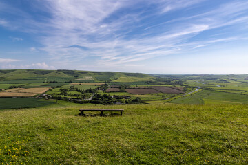A bench on Mount Caburn near Lewes with a view over fields and hills in the South Downs © lemanieh