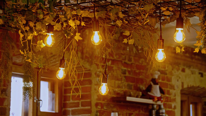 Beautiful hanging bulbs in the loft cafe. Stock footage. Barista making beverage at the coffee shop.