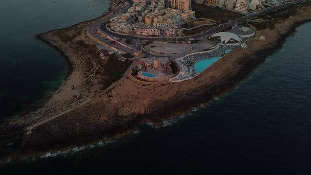 Malta National Aquarium aerial in the morning, during sunrise. Coastal road andmodern building. Rocky beach and Mediterranean sea. St. Paul's Bay, Malta. High quality 4k footage