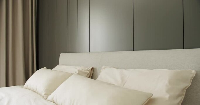 Elegance interior design. Minimalist Bedroom. Modern Hotel Bedroom Interior and bed with many pillows. minimalistic scandinavian style of interior. Interior of modern luxury bedroom with furniture.