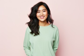 Fototapeta premium A woman with long hair is smiling and wearing a green shirt