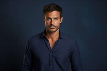 Obraz premium A man in a blue shirt is standing in front of a blue background