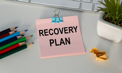 RECOVERY PLAN text on pink sheet of paper and thread table.