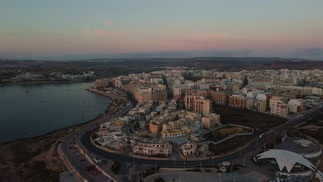 Qawra cityscape in the early morning, during the sunset. Revealing Qawra tower , and Malta National Aquarium. Aeral shot. High quality 4k footage