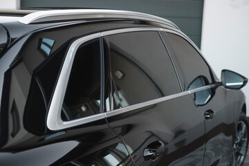 Fototapeta premium Modern black subcompact electric SUV in black. Exterior details. Large size wheels.