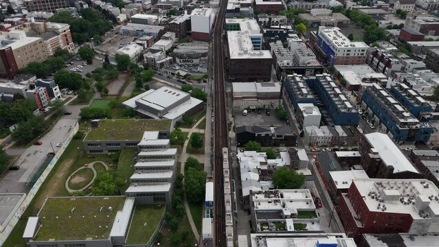 The photo captures a vibrant scene in Fishtown, Philadelphia, with the elevated Market-Frankford Line train 