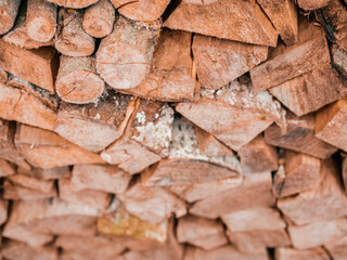 Stack of chopped firewood. Cheap budget heating material. Light brown wood color. Home comfort concept. Winter cold season preparation concept.