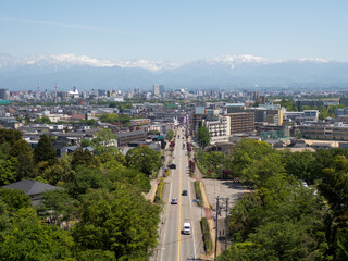 5月新緑の呉羽山富山県道44号富山高岡線を跨ぐ遊歩道吊橋から北アルプス立山連峰薬師岳富山市街地を望む