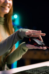 Joyous gen Z entertainer presenting wired gaming mouse from brand sponsoring video, urging viewers...
