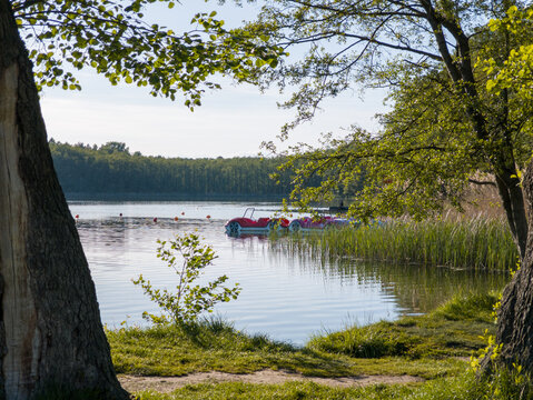 Scenic view at Strzeszynek lake (Jezioro Strzeszyńskie), recreational beach area near Rusałka lake in Poznan, Poland. Boats (catamarans) resting in the pond.