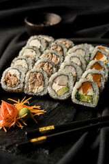 delicious sushi roll on a black stone plate