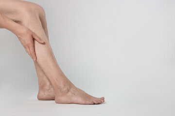 Closeup view of woman suffering from varicose veins on light background. Space for text