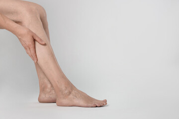 Closeup view of woman suffering from varicose veins on light background. Space for text