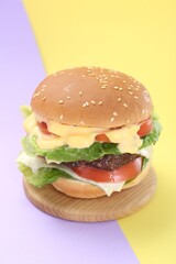 Burger with delicious patty on color background
