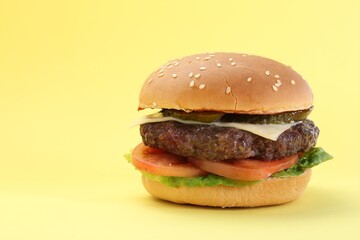 Burger with delicious patty on yellow background. Space for text
