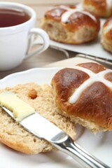 Tasty hot cross bun served on table, closeup