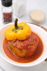 Delicious stuffed bell pepper served on white tiled table, closeup