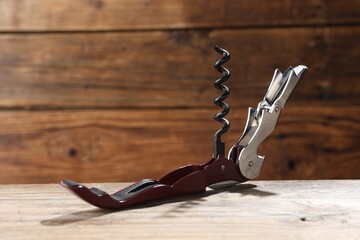 One corkscrew (sommelier knife) on wooden table, closeup
