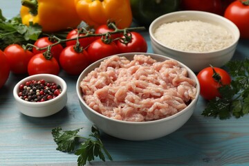 Making stuffed peppers. Ground meat and other ingredients on light blue wooden table