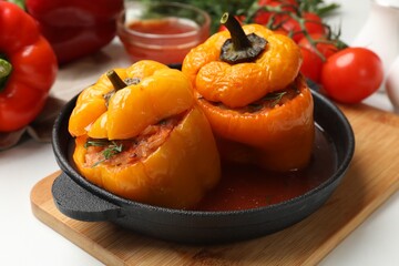 Tasty stuffed peppers in pan on light table, closeup