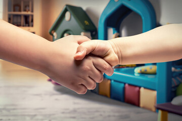 Obraz premium person shaking hands with a child, handshaking with a kid