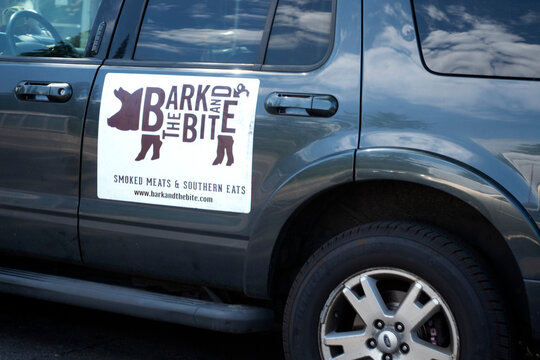 Advertising sign on the vehicle delivery door "Bark and the Bite" barbecue restaurant where you can eat in or take out. St Paul Minnesota MN USA