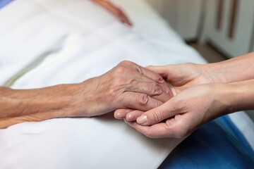 Fototapeta premium hands of the elderly person, holding hands, old patient ona bad of a hospital, taking care