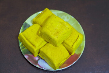 Close up of raw Yellow tofu on wooden plate and soy bean in a plate, with brown background, protein food, stock photo.