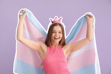 Happy young woman in crown with transgender flag on lilac background