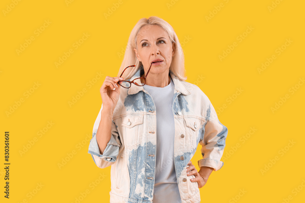 Sticker thoughtful mature woman with eyeglasses on yellow background