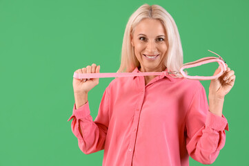 Mature woman with collar from sex shop on green background