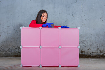 Girl sanding pink furniture in garage