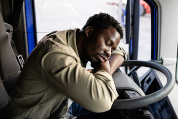 Overworked truck driver sleeping on steering wheel.