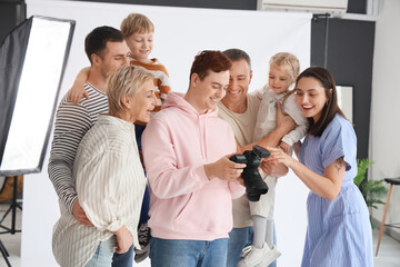 Male photographer showing taken pictures to family in studio