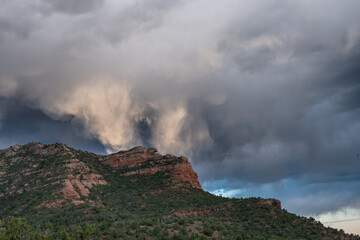Storm clouds reflect sunlight over red rocks formation near Sedona, Arizona
