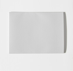 Textured card stock on white background, strong hard shadow