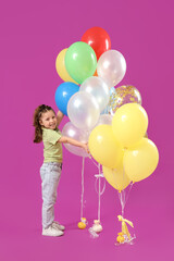 Cute little girl with balloons on purple background