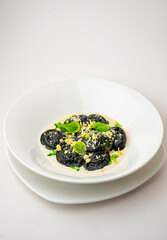 Black ravioli on a white background
