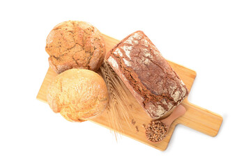 Wooden board with loaves of fresh bread, wheat spikelets and grains on white background