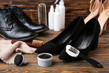 Shiny shoes and shoe cleaning tools on wooden background